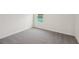 An empty bedroom with carpet and a window lets natural light into the house at 1855 Brekey Way, Zephyrhills, FL 33541