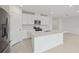 Bright, open kitchen featuring white cabinets, an island, and stainless steel appliances at 1855 Brekey Way, Zephyrhills, FL 33541