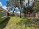 A lush backyard with mature trees and a privacy fence, providing a serene outdoor retreat at 5415 Riddle Rd, Holiday, FL 34690