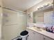 Bathroom features a shower and vanity with white cabinets and an neutral-toned countertop at 5415 Riddle Rd, Holiday, FL 34690