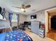 Bedroom featuring bunk beds, a ceiling fan, window, TV and a gray storage chest at 5415 Riddle Rd, Holiday, FL 34690