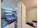Bright bedroom with a bunk bed, ceiling fan, and natural light with an ensuite bath that has a frosted shower at 5415 Riddle Rd, Holiday, FL 34690
