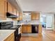 Well-lit kitchen features black appliances, light cabinetry, and convenient access to adjacent rooms for easy living at 5415 Riddle Rd, Holiday, FL 34690