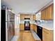 Functional kitchen features light wood cabinetry, black appliances, white countertops, and durable flooring at 5415 Riddle Rd, Holiday, FL 34690