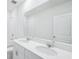 Modern bathroom features double vanity with white cabinets and large mirror above at 7728 Gilchrist Springs Dr, Parrish, FL 34219