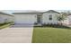 Well-maintained home featuring a two-car garage, freshly cut lawn, and attractive landscaping at 7728 Gilchrist Springs Dr, Parrish, FL 34219