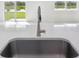 Close-up of the kitchen sink overlooking the backyard and lake at 7728 Gilchrist Springs Dr, Parrish, FL 34219
