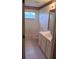 Bathroom with white tiled walls, white cabinets, sink and toilet, and tub with shower at 10415 Lucaya Dr, Tampa, FL 33647