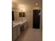 Bathroom with double sinks, large mirror, hooks for towels and a door to the walk-in closet at 10415 Lucaya Dr, Tampa, FL 33647