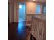 Hallway with dark wood floors and view of bathroom featuring a toilet and shower at 10415 Lucaya Dr, Tampa, FL 33647