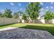 Landscaped backyard featuring lush green grass, a white fence, and a stylish stone patio at 13083 Burns Dr, Odessa, FL 33556