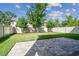 Spacious backyard with a well-maintained lawn, white fence, and stone-paved patio at 13083 Burns Dr, Odessa, FL 33556