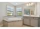 Bright bathroom features a soaking tub, tiled surround and double windows for relaxing, natural light at 13083 Burns Dr, Odessa, FL 33556