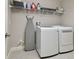 Convenient laundry room features washer, dryer, shelving, and an ironing board for easy chores at 13083 Burns Dr, Odessa, FL 33556