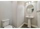 Half bathroom with a pedestal sink, white fixtures, and wood-look flooring at 13083 Burns Dr, Odessa, FL 33556