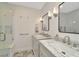 Well-lit bathroom features a double vanity with marble countertops and a glass-enclosed shower at 709 S Himes Ave, Tampa, FL 33609
