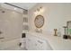 Modern bathroom with herringbone tile, round mirror, and white vanity at 709 S Himes Ave, Tampa, FL 33609