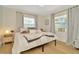 Bright bedroom with windows, wood floor, stylish bedding, and a nightstand at 709 S Himes Ave, Tampa, FL 33609