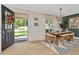Elegant dining room with modern chandelier, table set for four and an open front door at 709 S Himes Ave, Tampa, FL 33609
