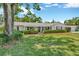 Charming single-story home featuring a well-manicured lawn and mature trees with a lovely front porch at 709 S Himes Ave, Tampa, FL 33609