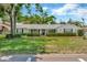 Charming single-story home featuring a well-manicured lawn and mature trees with a lovely front porch at 709 S Himes Ave, Tampa, FL 33609
