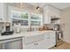 Bright kitchen features marble backsplash, white cabinets, stainless steel appliances and a farmhouse sink at 709 S Himes Ave, Tampa, FL 33609