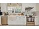 Well-lit kitchen featuring stainless steel appliances, white cabinetry, and marble backsplash at 709 S Himes Ave, Tampa, FL 33609