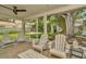 Covered patio with ceiling fan and white Adirondack chairs overlooking landscaped backyard at 709 S Himes Ave, Tampa, FL 33609