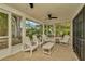 Screened in porch with ceiling fan and white Adirondack chairs at 709 S Himes Ave, Tampa, FL 33609