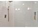 The updated shower features a rainfall showerhead, white subway tile and a built-in storage niche at 709 S Himes Ave, Tampa, FL 33609