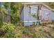 Side view of home featuring window and overgrown landscaping at 9307 N Oakleaf Ave, Tampa, FL 33612