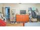 Bedroom featuring hardwood floors and a dresser, leading to another room at 9307 N Oakleaf Ave, Tampa, FL 33612
