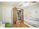 Bedroom with wood floors, barn door closet, and ceiling fan at 9307 N Oakleaf Ave, Tampa, FL 33612
