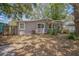 Charming single-story home featuring a well-maintained facade, a gravel yard and mature trees at 9307 N Oakleaf Ave, Tampa, FL 33612