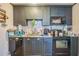 Functional kitchen features dark cabinets, granite countertops, tile backsplash, and modern appliances at 9307 N Oakleaf Ave, Tampa, FL 33612