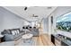 Inviting living room with modern decor, wood floors, ceiling fans, and a view of the kitchen at 5016 W Lancaster St # 00, Tampa, FL 33616