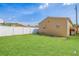 Backyard with a white fence, green grass, and a tan shed at 10227 Parsons St, Tampa, FL 33615