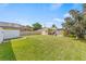 Large backyard with a detached garage, green lawn, and beautiful surrounding trees at 10227 Parsons St, Tampa, FL 33615