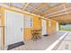 Covered porch featuring a table with chairs, a doormat, and white trim at 10227 Parsons St, Tampa, FL 33615