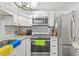 Modern kitchen featuring stainless steel appliances, granite countertops, and sleek white cabinets at 10227 Parsons St, Tampa, FL 33615