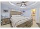 Comfortable main bedroom with a ceiling fan, a tray ceiling, and a bathroom view at 10227 Parsons St, Tampa, FL 33615