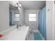 Well-lit bathroom featuring a modern vanity, sleek fixtures, and a stylish blue shower curtain at 1073 Kenwood Dr, Dunedin, FL 34698
