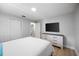 The bedroom features light wood flooring, a dresser and a large mounted TV at 1073 Kenwood Dr, Dunedin, FL 34698