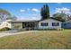 Charming single-story home with well-maintained lawn and inviting front porch at 1073 Kenwood Dr, Dunedin, FL 34698
