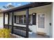 Charming front porch with black railings, white door, and 