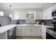 Kitchen showcases modern stainless steel appliances, grey backsplash and quartz countertops at 1073 Kenwood Dr, Dunedin, FL 34698
