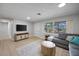 Stylish living room with wood floors, natural light, and a contemporary entertainment center at 1073 Kenwood Dr, Dunedin, FL 34698