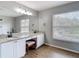 Bright bathroom features double sinks, a vanity with stool, and a large framed mirror at 18109 Kara Ct, Tampa, FL 33647