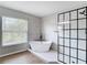 Modern bathroom featuring a soaking tub, a walk-in shower with black grid and white hexagon tile flooring at 18109 Kara Ct, Tampa, FL 33647