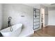 Bright bathroom featuring a soaking tub, a black grid shower, gray tiled walls, and wood-look floors at 18109 Kara Ct, Tampa, FL 33647